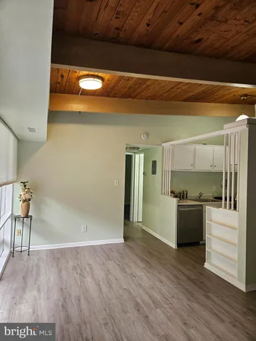 a kitchen with a wooden floor and a refrigerator