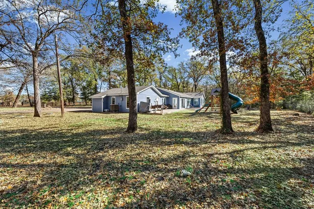 a view of a yard with wooden fence