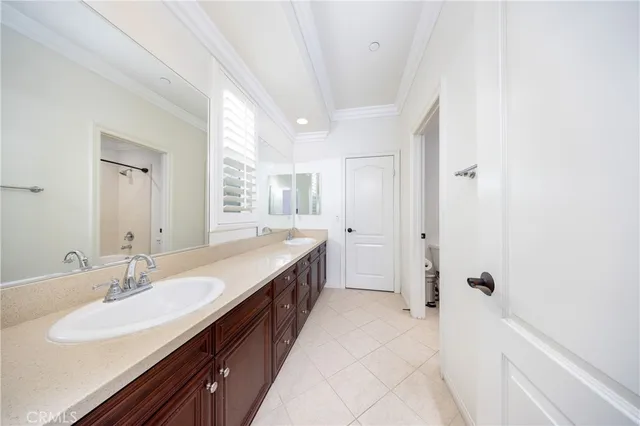 a spacious bathroom with a double vanity sink a mirror and a bathtub