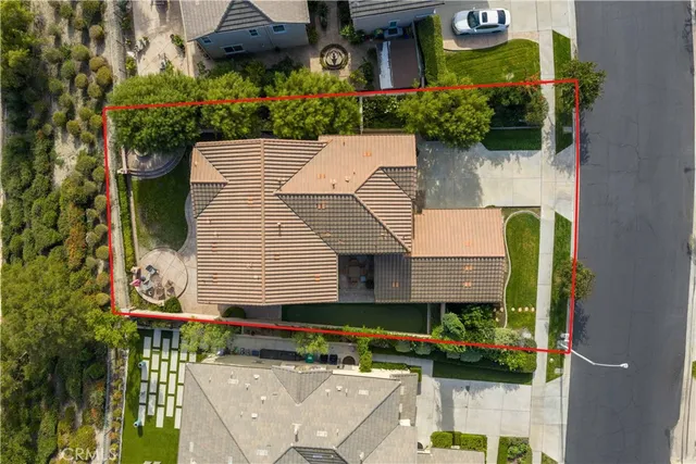 an aerial view of a house with a yard and large trees