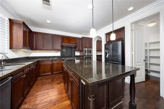 a kitchen with stainless steel appliances granite countertop a sink a stove and kitchen island