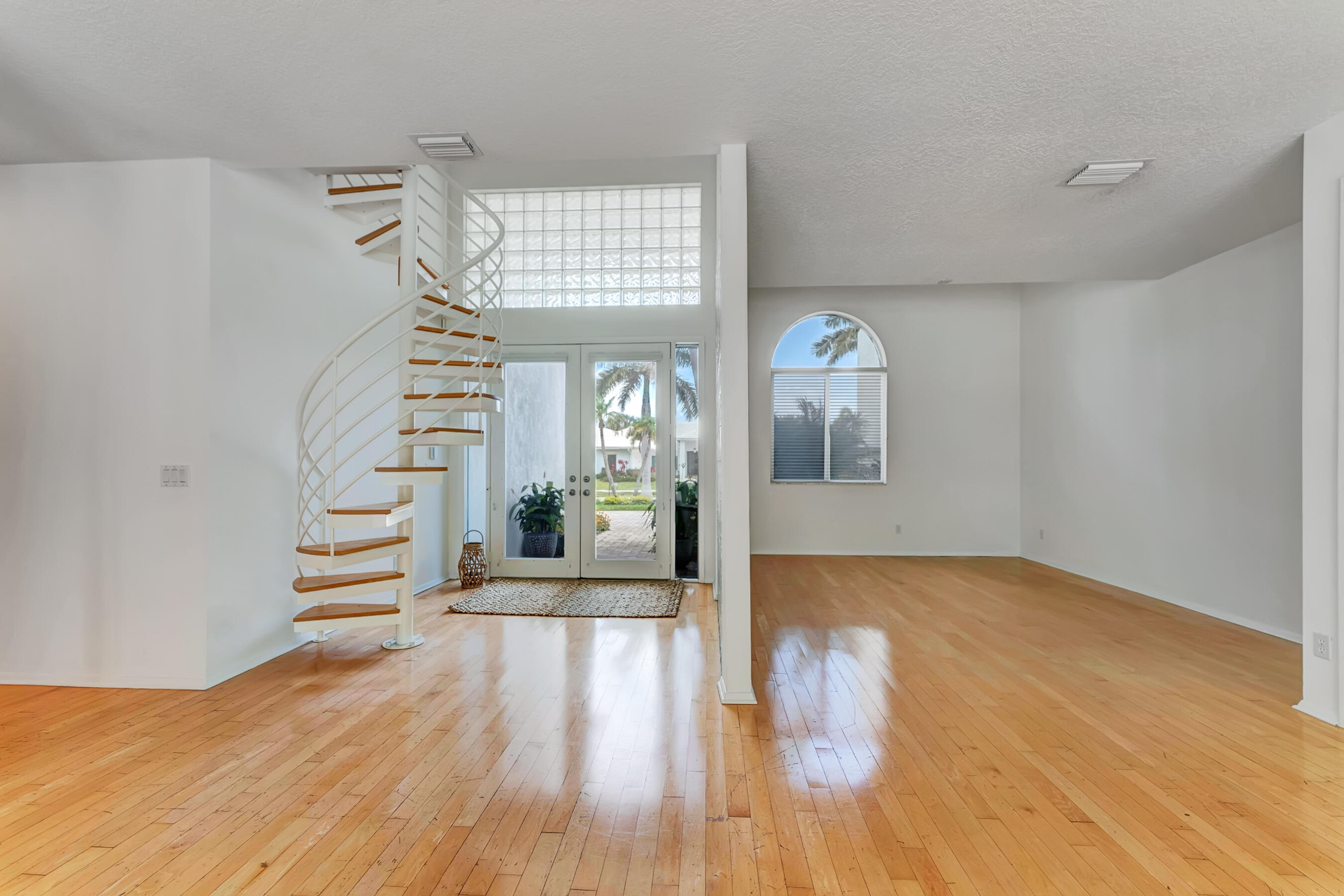 114 Olympus Circle Jupiter, FL 33477 - Photo 12 of 88 a view of an empty room with wooden floor and a window