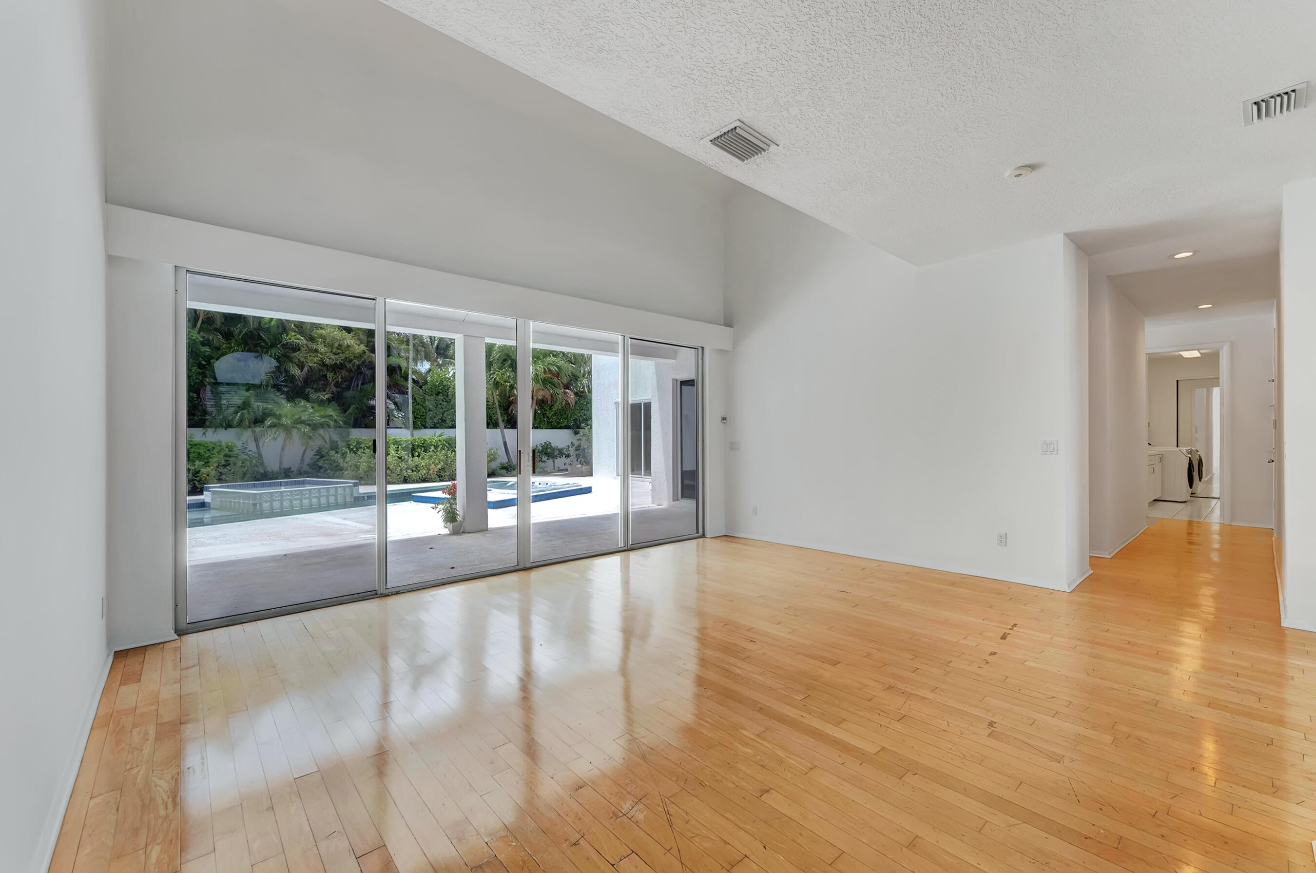 114 Olympus Circle Jupiter, FL 33477 - Photo 16 of 88 a view of an empty room with wooden floor and a window