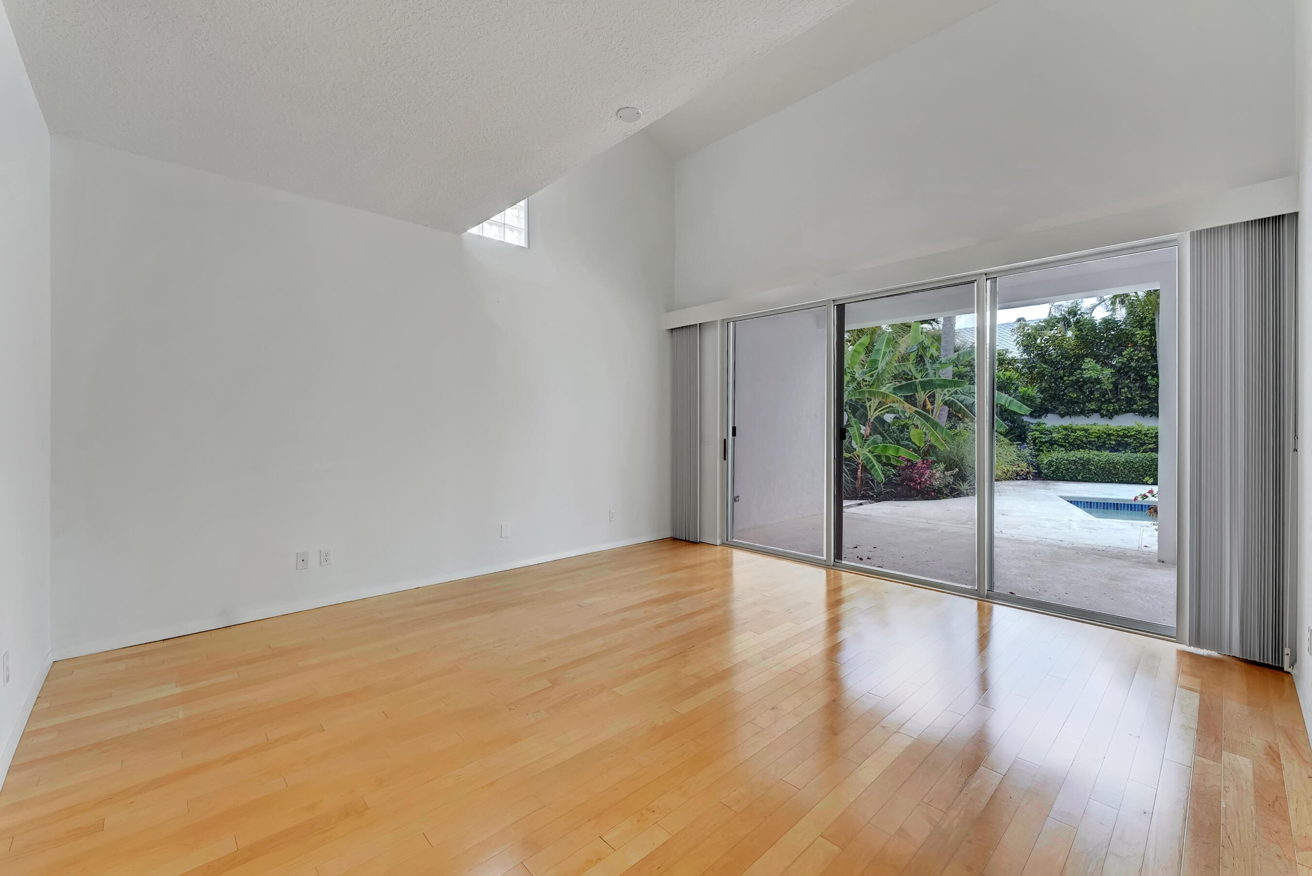 114 Olympus Circle Jupiter, FL 33477 - Photo 34 of 88 a view of an empty room with wooden floor and a window
