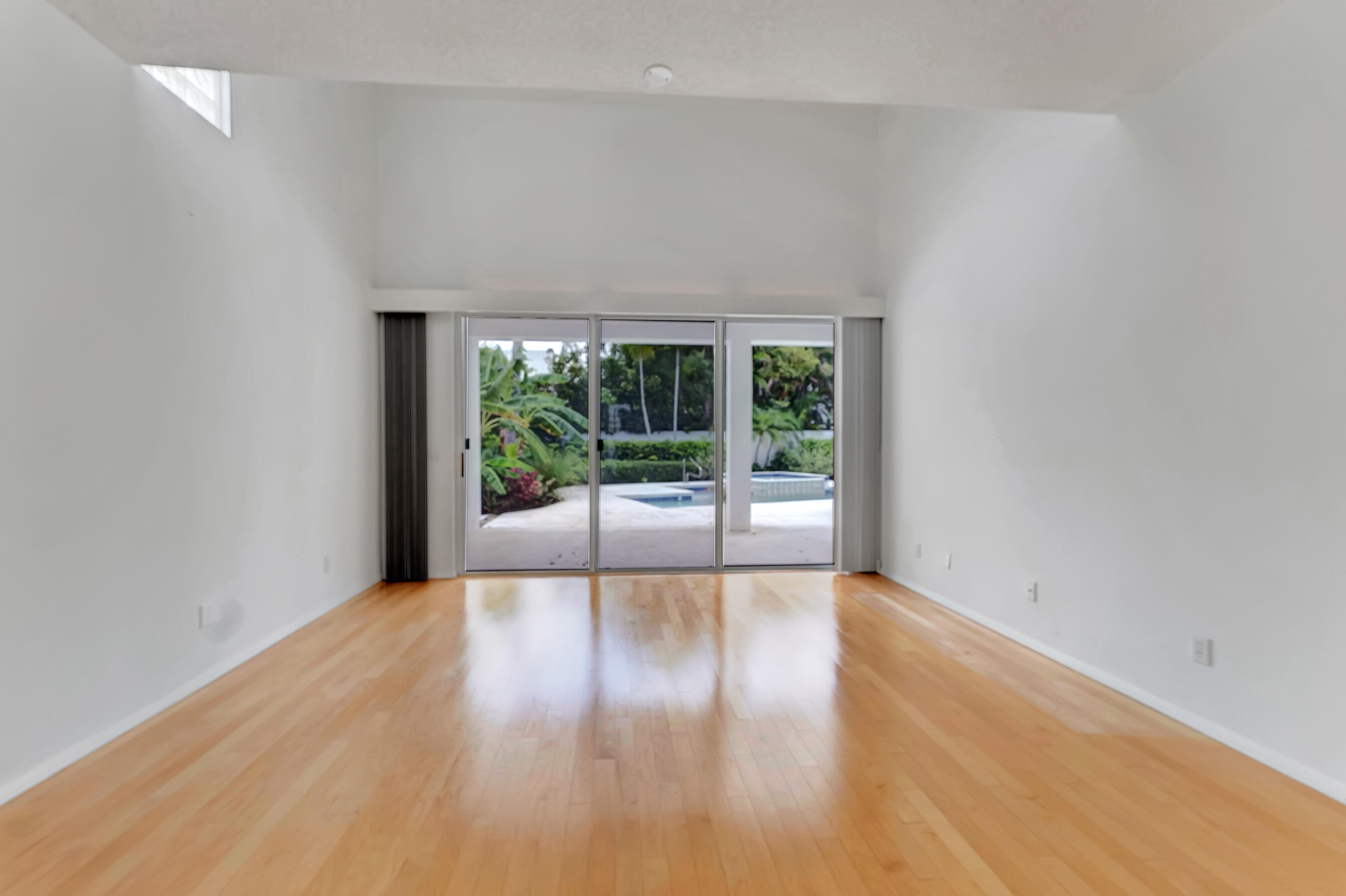 114 Olympus Circle Jupiter, FL 33477 - Photo 35 of 88 a view of an empty room with wooden floor and a window