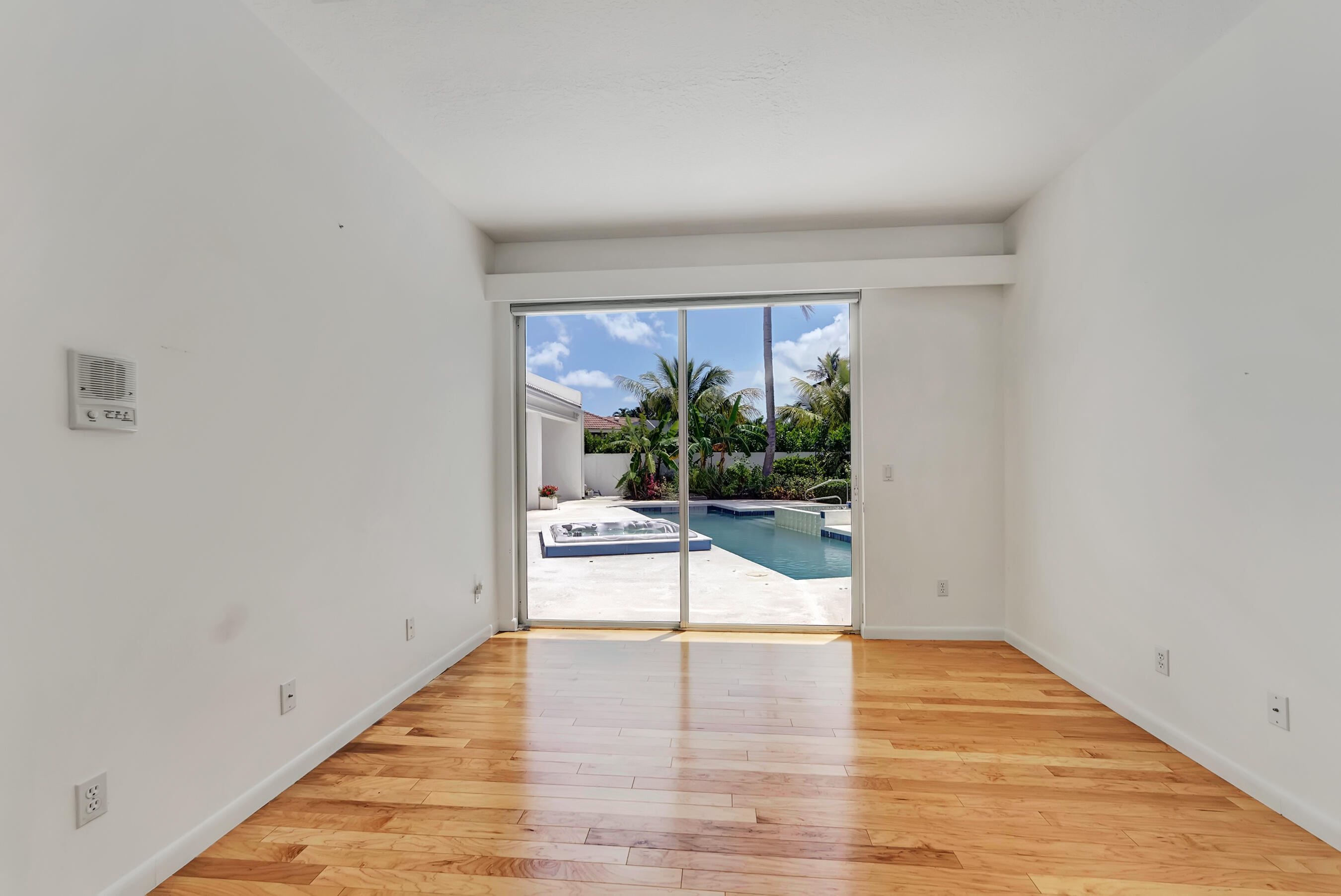 114 Olympus Circle Jupiter, FL 33477 - Photo 42 of 88 a view of an empty room with wooden floor and a window