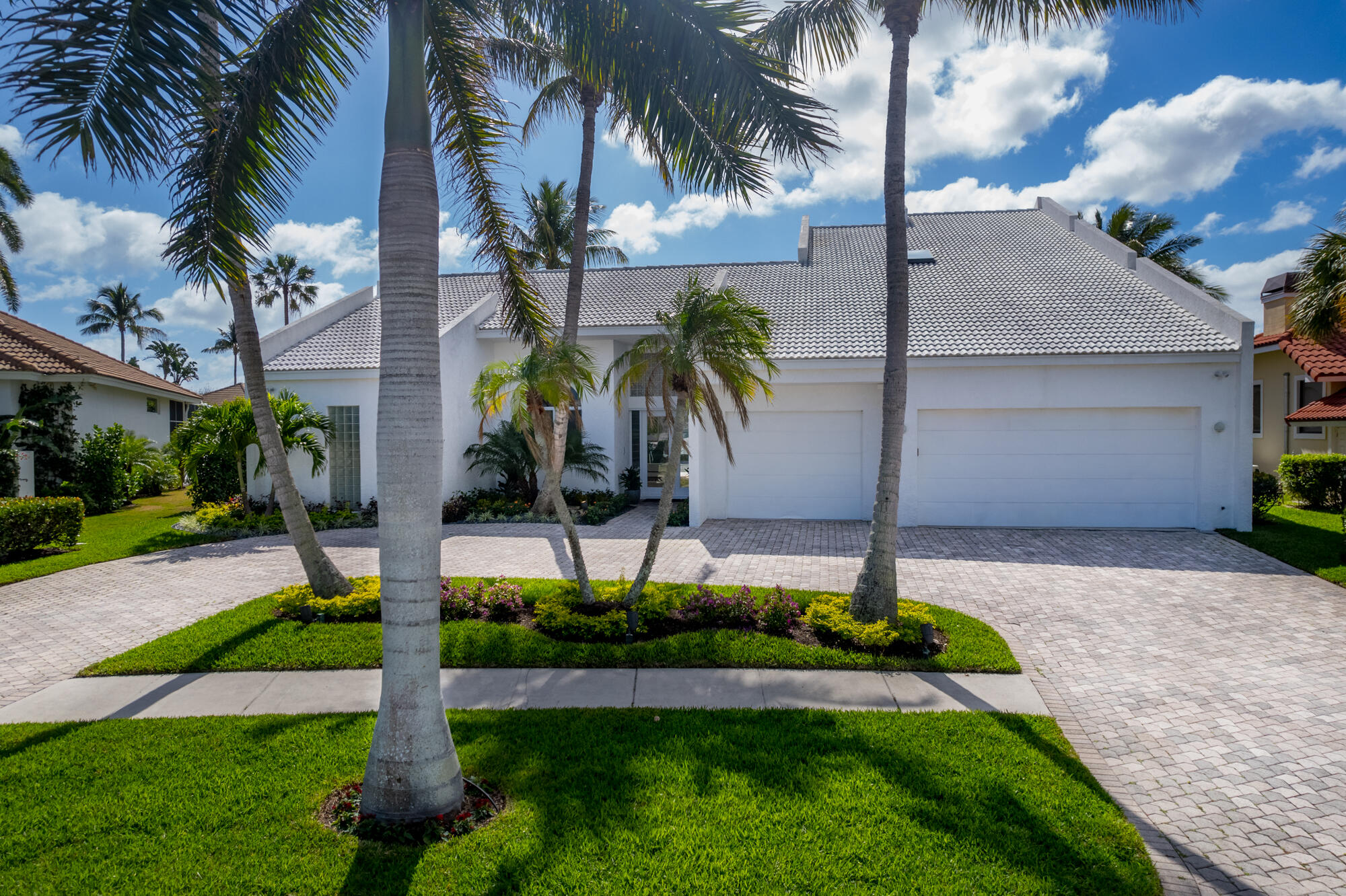 114 Olympus Circle Jupiter, FL 33477 - Photo 6 of 88 a front view of multi story residential apartment building with yard and green space