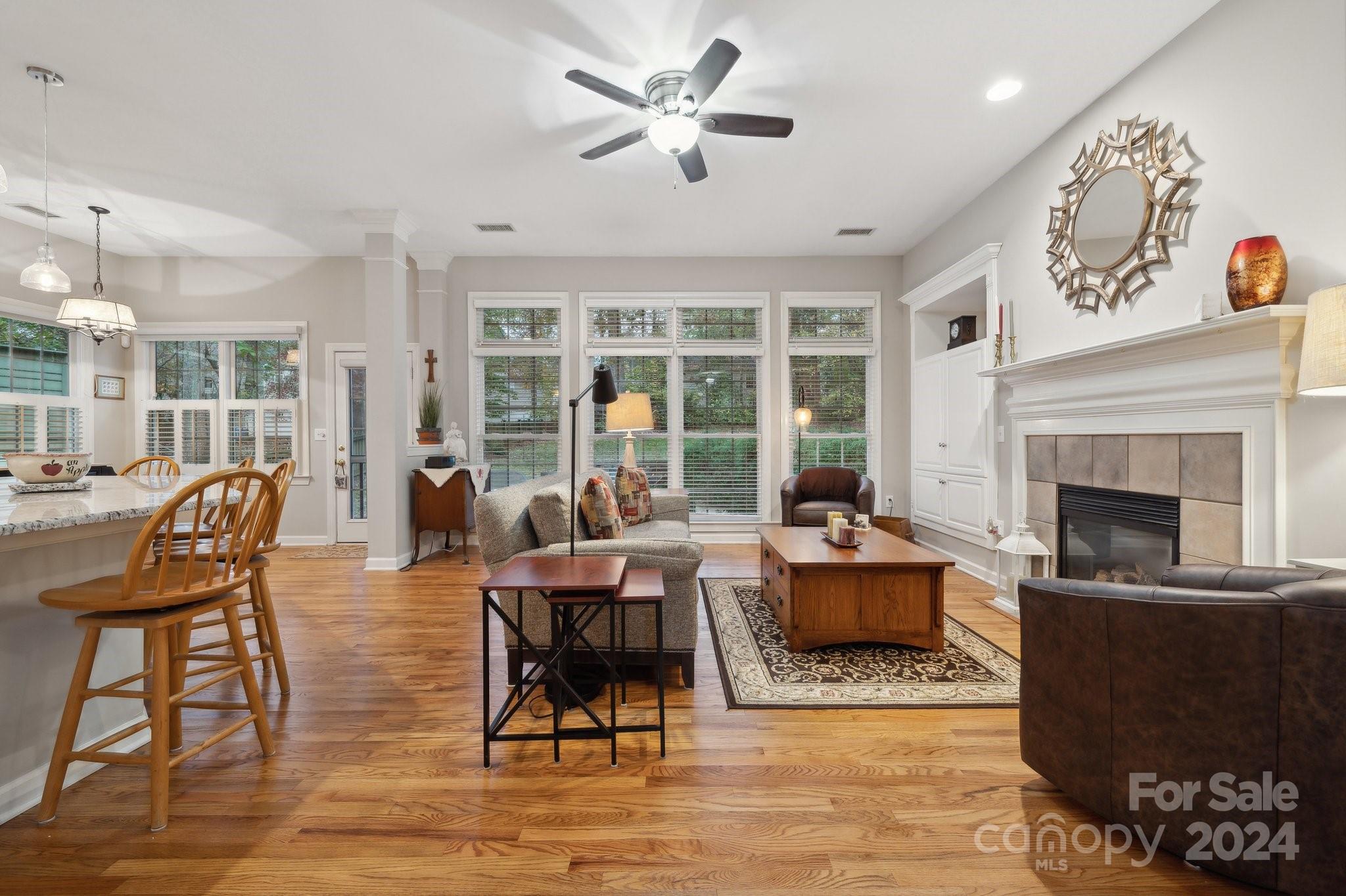 8610 Brentfield Road Huntersville, NC 28078 - Photo 16 of 48 a living room with furniture a fireplace and a floor to ceiling window
