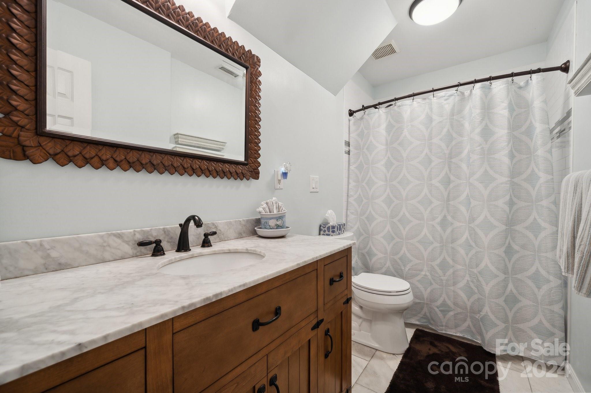 8610 Brentfield Road Huntersville, NC 28078 - Photo 29 of 48 a bathroom with a granite countertop sink a toilet and a mirror