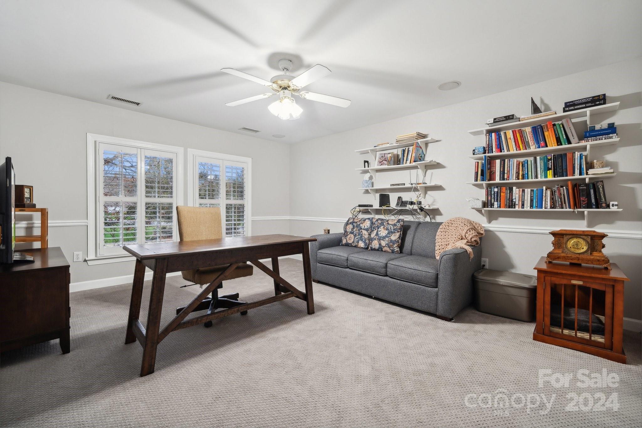 8610 Brentfield Road Huntersville, NC 28078 - Photo 33 of 48 a living room with furniture a bookshelf and a bookshelf