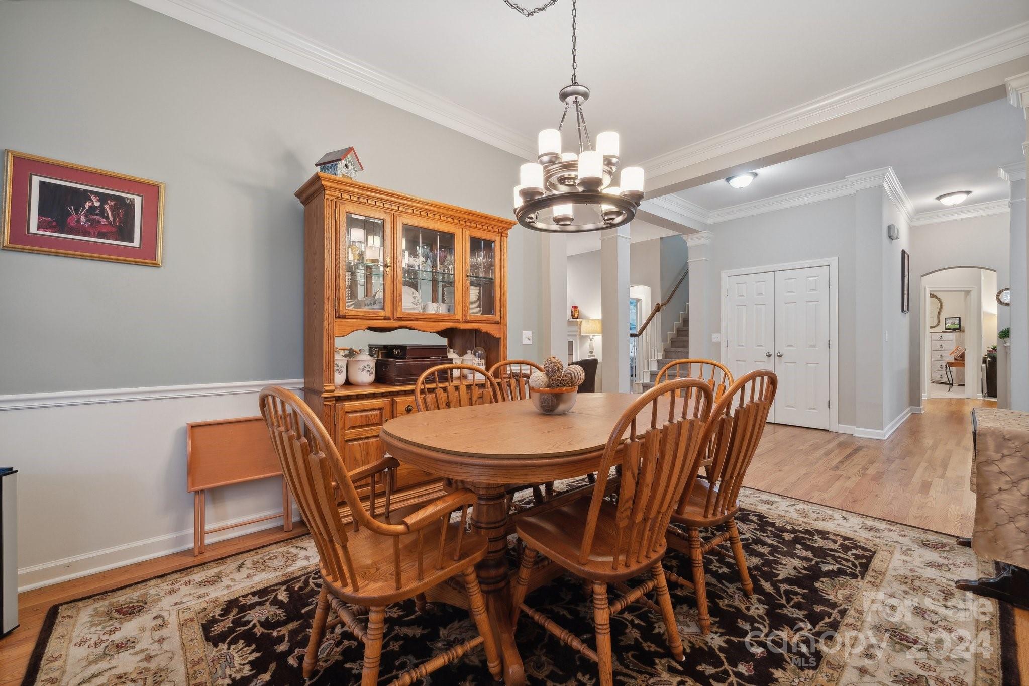 8610 Brentfield Road Huntersville, NC 28078 - Photo 7 of 48 a view of a dining room with furniture a chandelier and wooden floor
