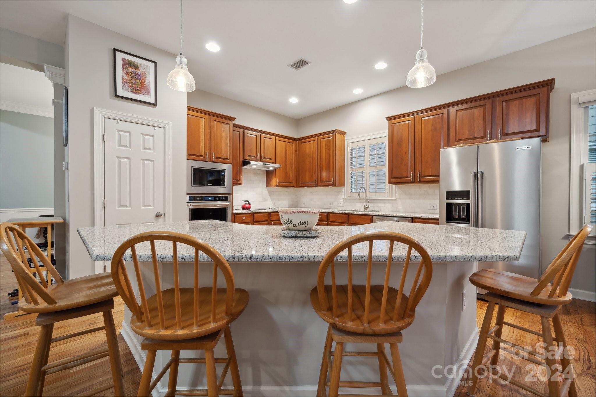 8610 Brentfield Road Huntersville, NC 28078 - Photo 9 of 48 a kitchen with stainless steel appliances granite countertop a table chairs and a refrigerator