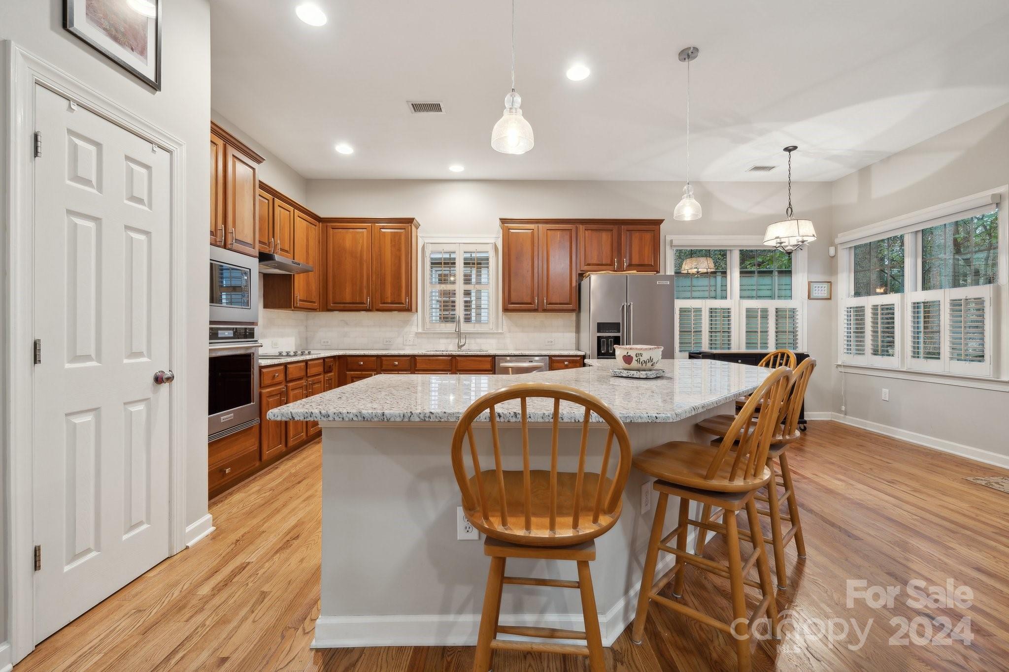 8610 Brentfield Road Huntersville, NC 28078 - Photo 10 of 48 a view of a kitchen with granite countertop lots of wooden cabinets a sink and a window