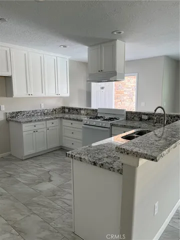 a kitchen with stainless steel appliances granite countertop a sink stove and cabinets