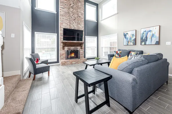 a living room with furniture a fireplace and a flat screen tv