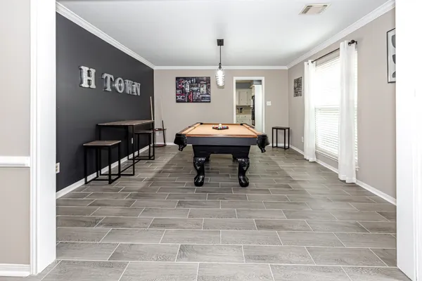 a room with pool table and windows