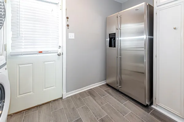 a view of a refrigerator in kitchen and white cabinets