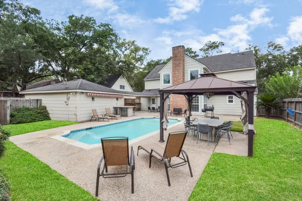a view of a house with backyard sitting area and garden