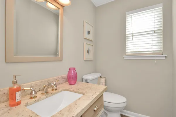 a bathroom with a sink toilet and a mirror