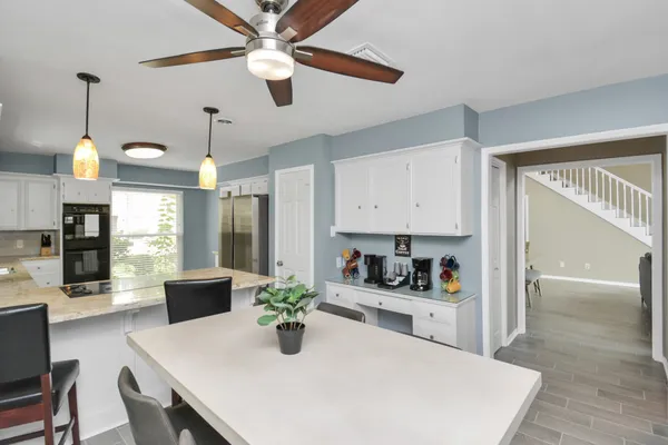 a kitchen with a table chairs and white cabinets