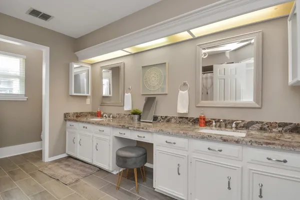 a bathroom with a granite countertop sink and a mirror