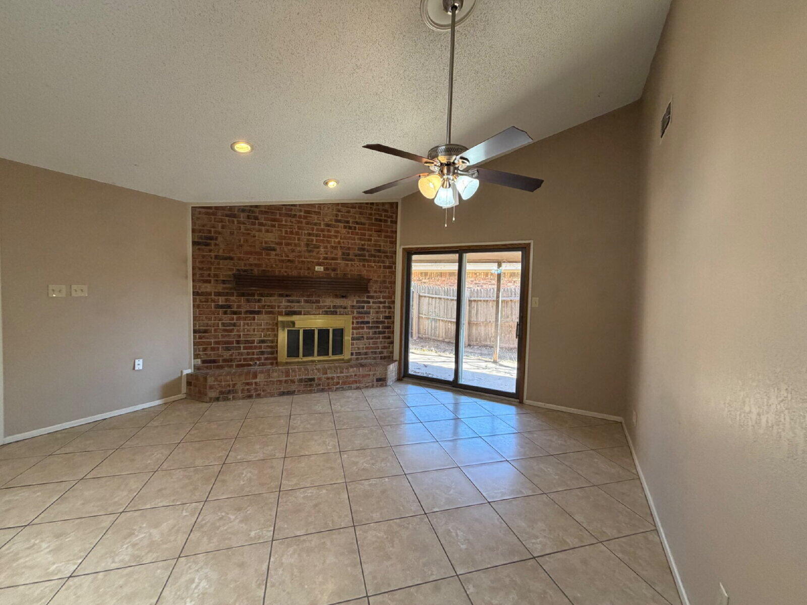 3107 75th Street, Unit A Lubbock, TX 79423 - Photo 3 of 12 a view of an empty room with a fireplace and a window