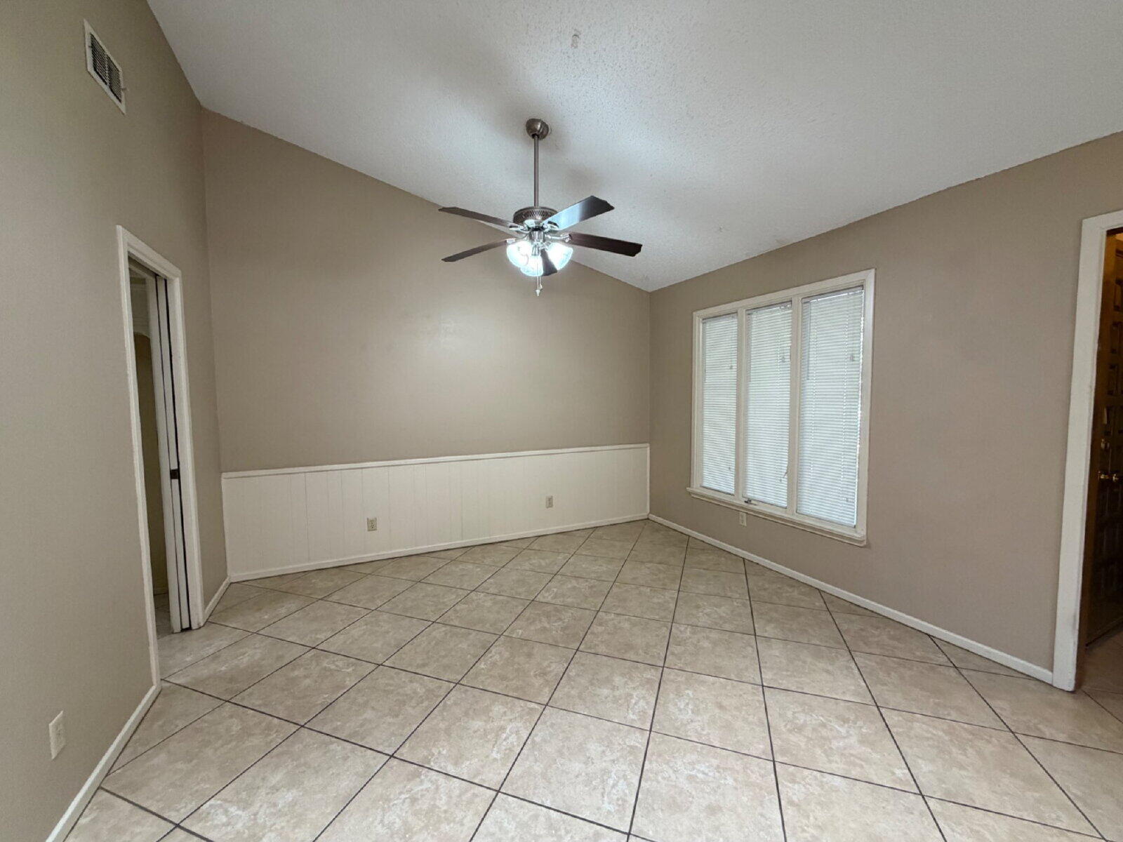 3107 75th Street, Unit A Lubbock, TX 79423 - Photo 4 of 12 an empty room with windows and fan