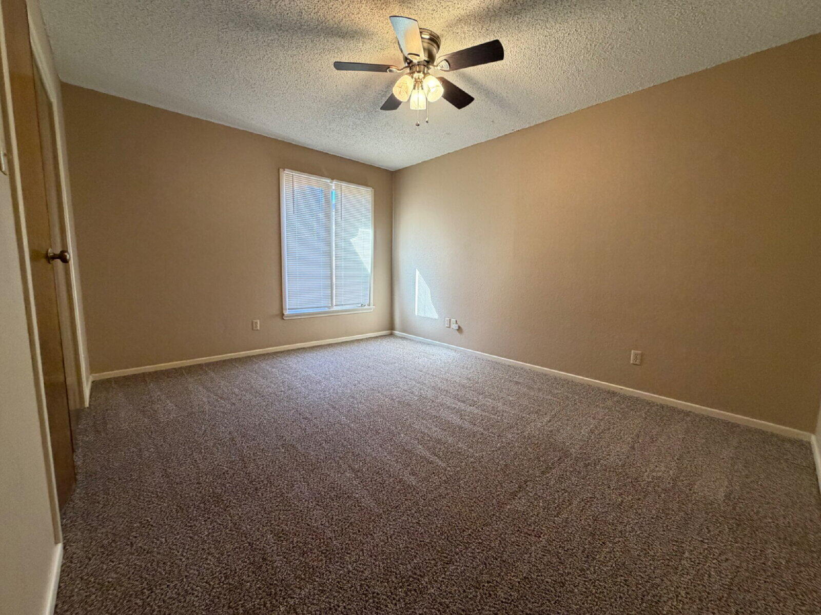 3107 75th Street, Unit A Lubbock, TX 79423 - Photo 7 of 12 a view of a room with a ceiling fan and a window