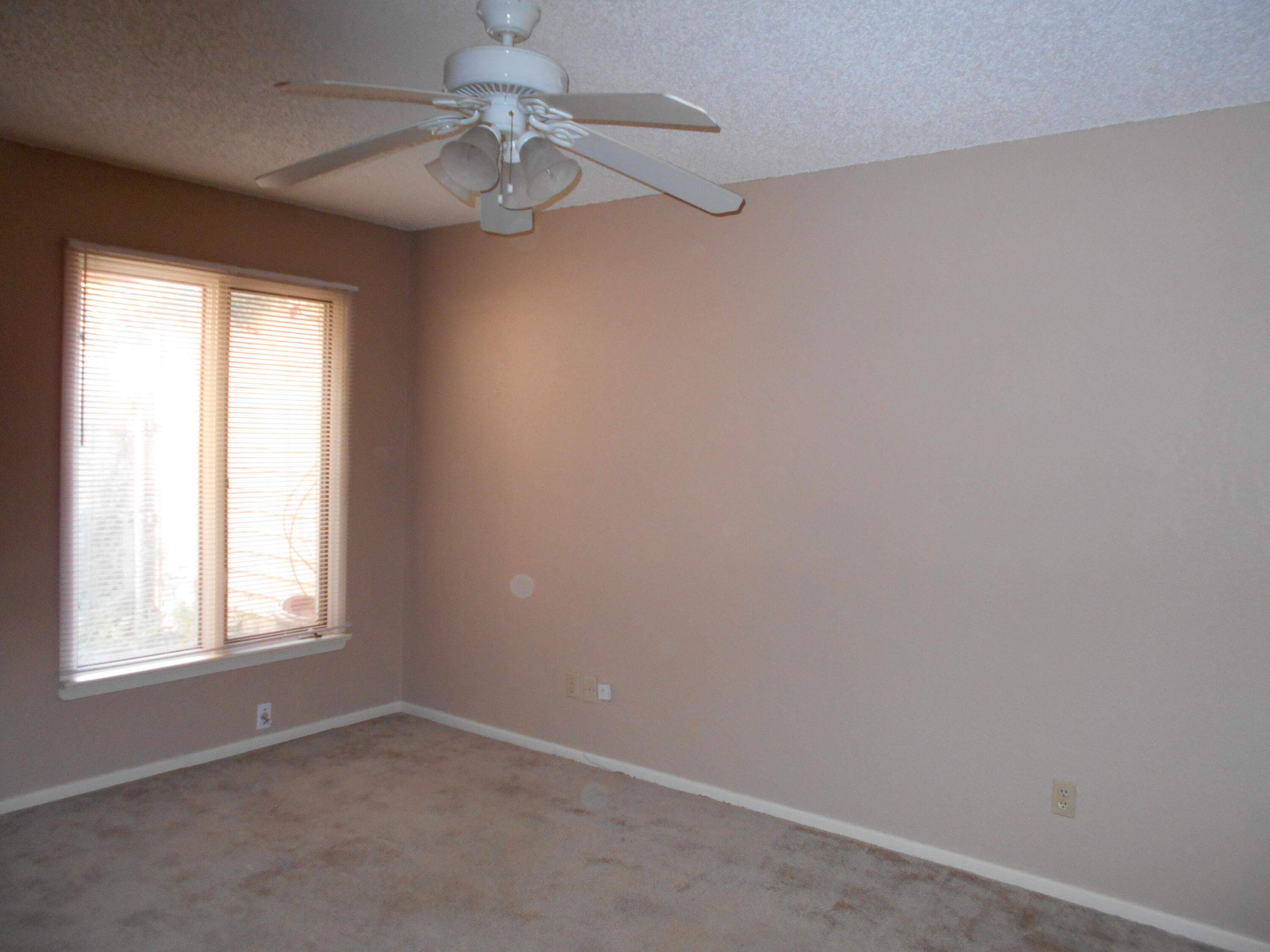 3107 75th Street, Unit A Lubbock, TX 79423 - Photo 9 of 12 an empty room with a window and a fan