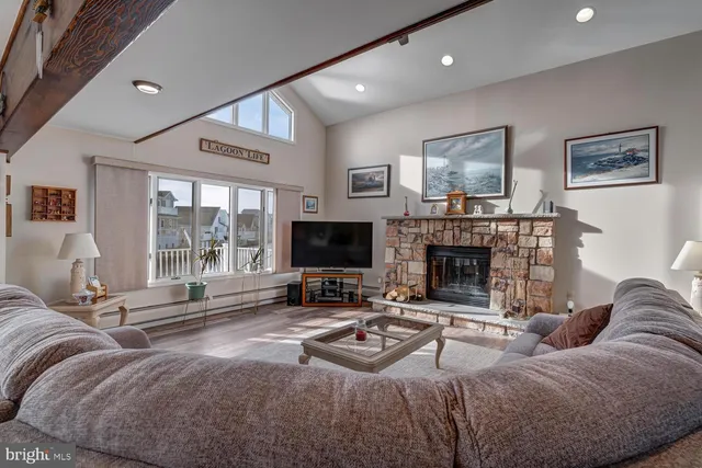 a living room with furniture a flat screen tv and a fireplace