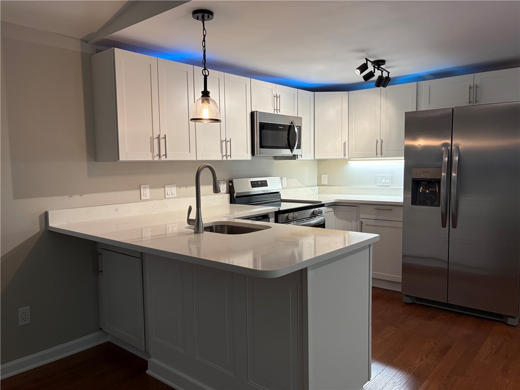 205 Lynden Loop Westminster, SC 29693 - Photo 4 of 16 Streamlined cabinetry and pristine quartz countertops define this culinary workspace with warm hardwood floors.