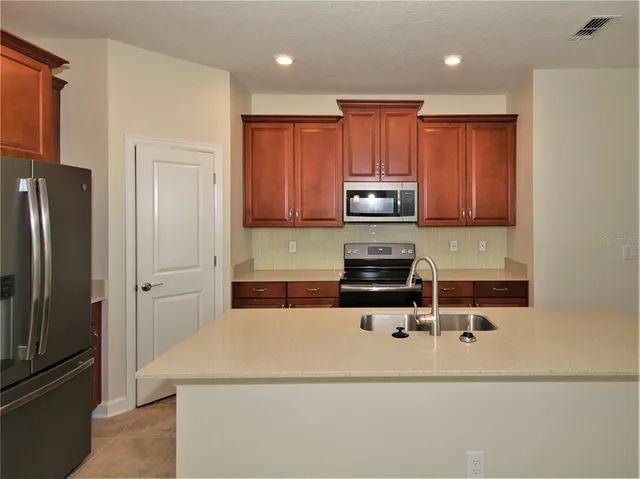 a kitchen with a refrigerator a microwave and cabinets
