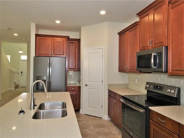 a kitchen with stainless steel appliances granite countertop a sink refrigerator and microwave