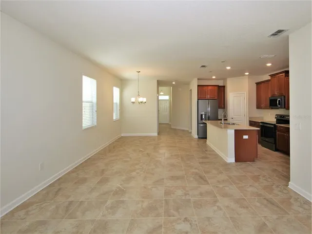 a view of kitchen with kitchen island wooden cabinets and refrigerator