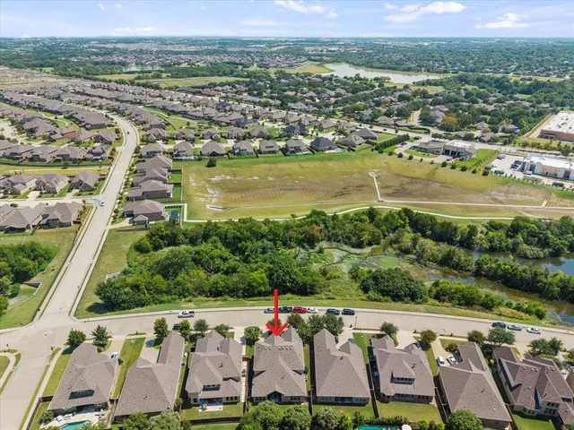 an aerial view of ocean and residential houses with outdoor space