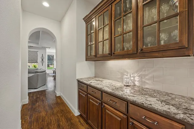 a kitchen with granite countertop stainless steel appliances and wooden floor