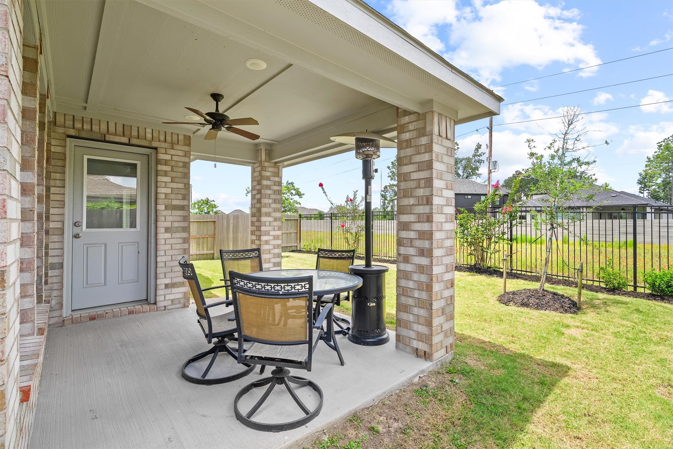 17270 Wild Watermelon Way Conroe, TX 77302 - Photo 23 of 28 Texas evenings were made for this. The covered patio with a ceiling fan, brick columns, and a fenced backyard with green space just beyond the fence gives you the kind of outdoor living that makes staying home feel like a vacation.