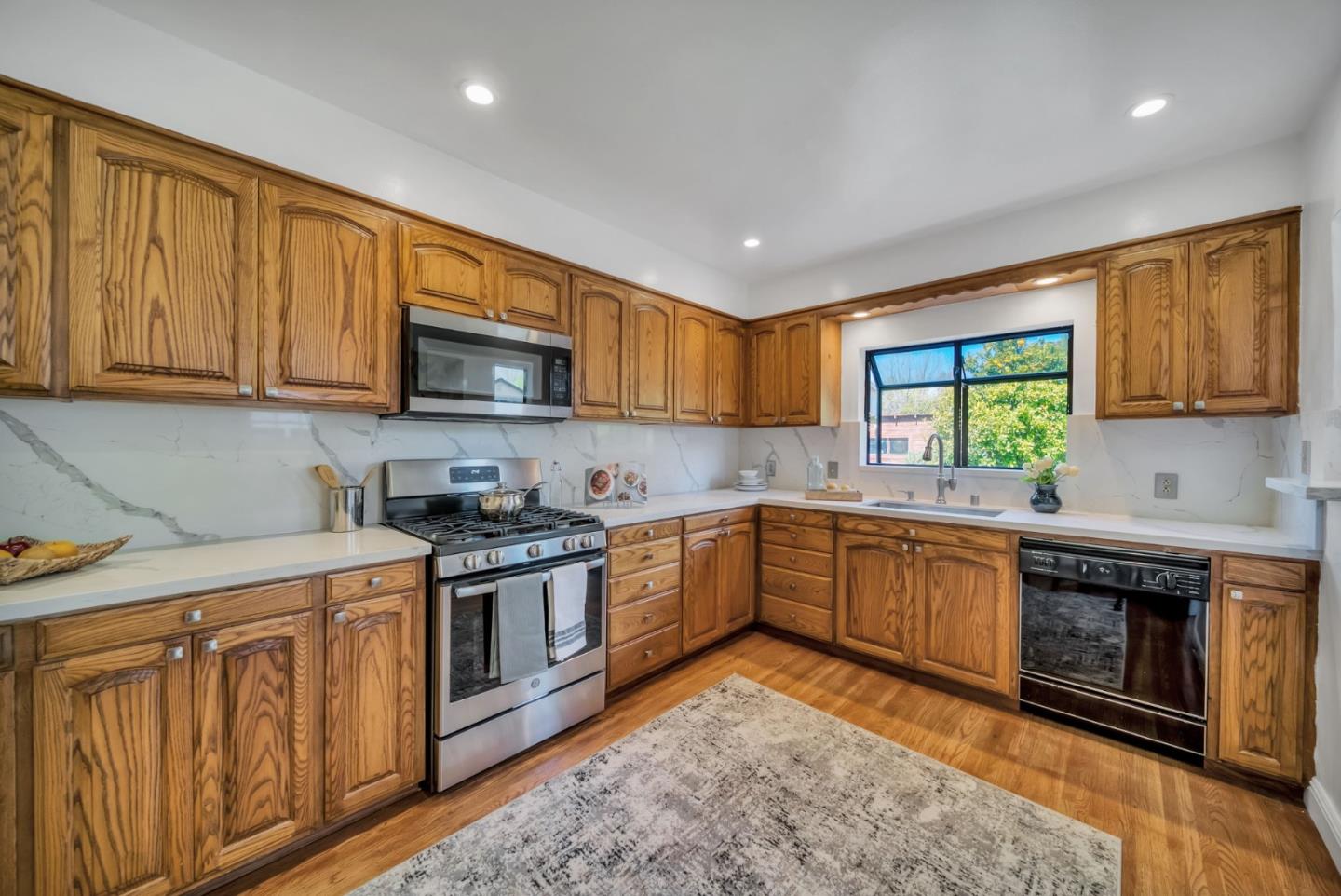 132 Dwight Road Burlingame, CA 94010 - Photo 18 of 69 a kitchen with stainless steel appliances granite countertop wooden cabinets granite counter tops and a stove top oven
