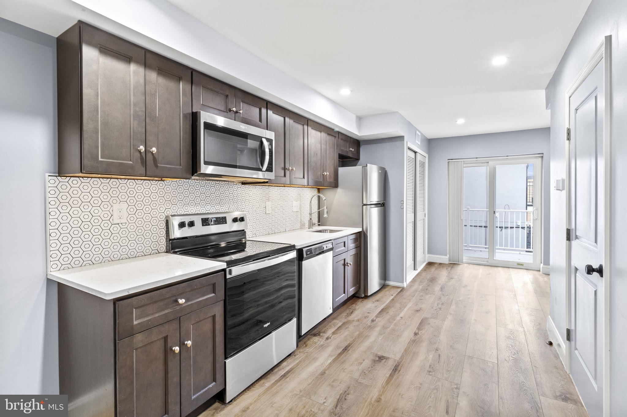 418 South 15th Street, Unit 2R Philadelphia, PA 19146 - Photo 7 of 26 a kitchen with stainless steel appliances granite countertop a stove a sink and a refrigerator