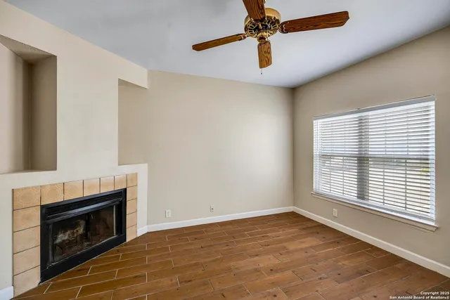 a view of empty room with fireplace and fan