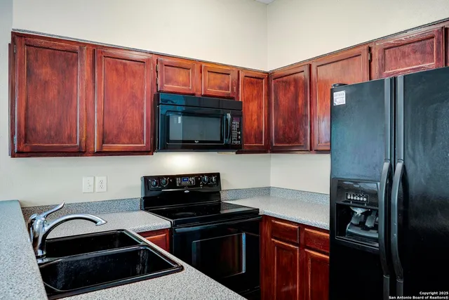 a kitchen with a sink a refrigerator and cabinets