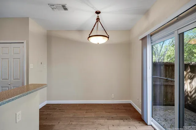 a view of a room with wooden floor and windows
