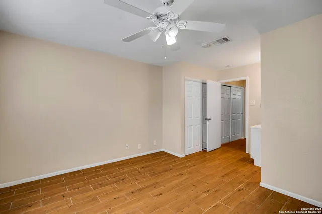 a view of a big room with wooden floor and a ceiling fan