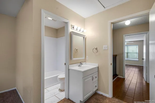 a spacious bathroom with a double vanity sink a toilet and a mirror