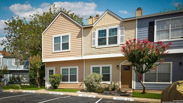 a view of a house with a yard and a tree