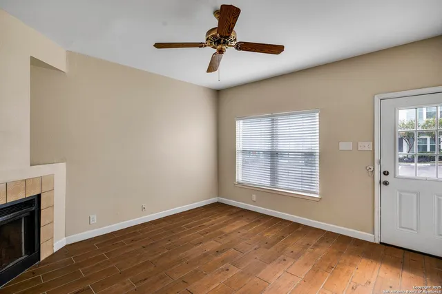 a view of empty room with wooden floor and fireplace