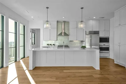 a large kitchen with kitchen island a large counter top space a sink stainless steel appliances and cabinets