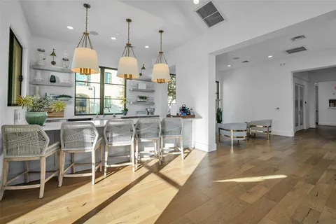 a room with lots of white furniture and wooden floor