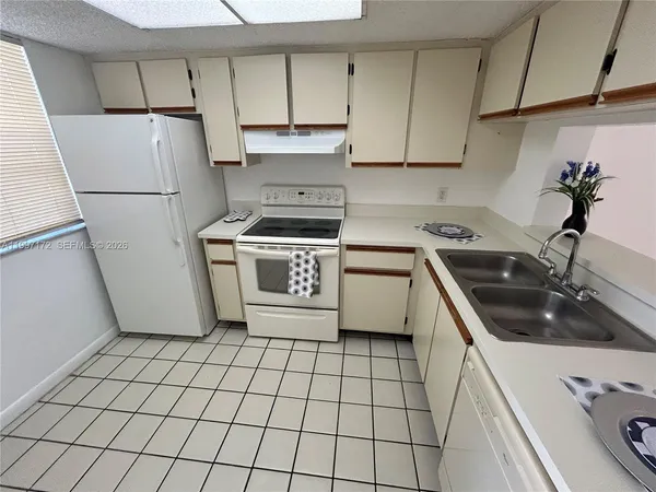 a kitchen with a stove a refrigerator sink and cabinets