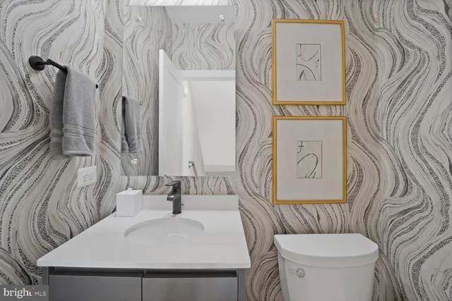 a en suite bathroom with a granite countertop sink and a mirror